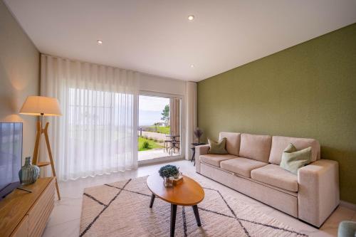 a living room with a couch and a table at New Luxury Apartment, Sea View with Pool & Gym in Nazaré