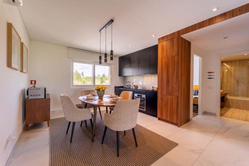 a kitchen and dining room with a table and chairs at New Luxury Apartment, Sea View with Pool & Gym in Nazaré