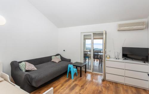 a living room with a couch and a table and a television at Awesome Apartment In Omisalj With Wifi in Omišalj