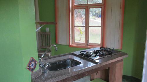 a kitchen with a sink and a window at Pousada Alquimia in Aiuruoca