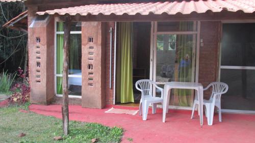 a small house with a table and chairs on a patio at Pousada Alquimia in Aiuruoca