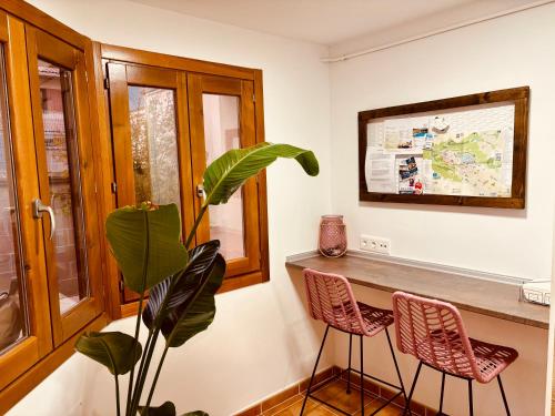 a room with a counter with two chairs and a plant at Casa VillaFlamenca in Segovia
