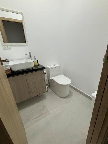 a white bathroom with a sink and a toilet at Luxurious apartment Jama Manabí in Jama