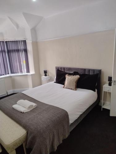 Un dormitorio con una cama grande con dos toallas encima. en Mancunian Pride Villa, en Mánchester