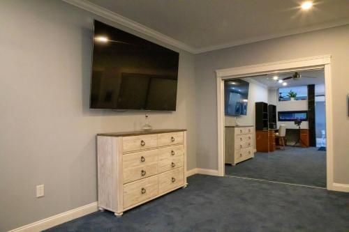 a bedroom with a dresser and a tv on the wall at Riverside Retreat Waterfront Guest House in Groton