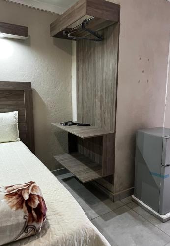 a bedroom with a bed and a wooden cabinet at Private 4 Double Room Guest Wing, Comfortable, Secure Parking, Wi-Fi, Ensuite Bath in Ermelo