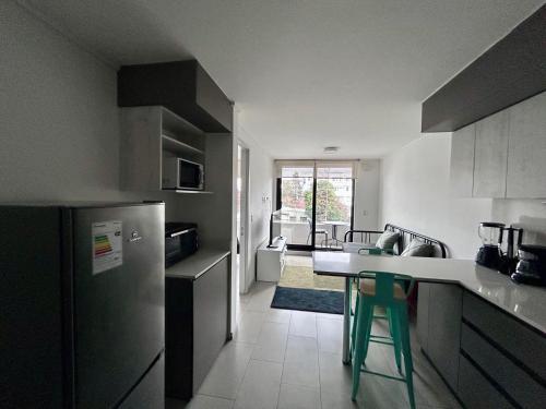 a kitchen with a refrigerator and a table in it at Departamento central, exclusivo in El Cerrillo