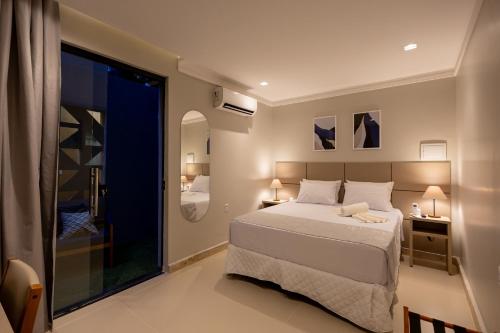a bedroom with a bed and a large window at Aira Hotel in Sobral