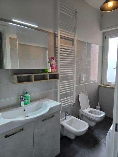 a white bathroom with a sink and a toilet at Civico138 in Verona
