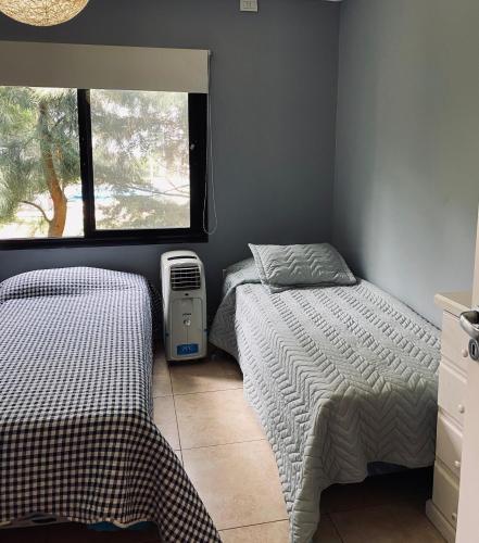 a bedroom with two twin beds and a window at Casa de campo, paz, tranquilidad in Concordia
