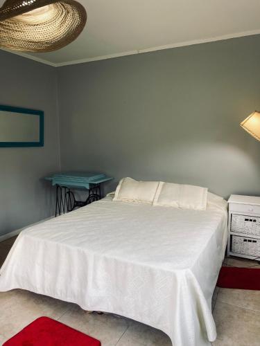 ein Schlafzimmer mit einem weißen Bett und einem blauen Tisch in der Unterkunft Casa de campo, paz, tranquilidad in Concordia