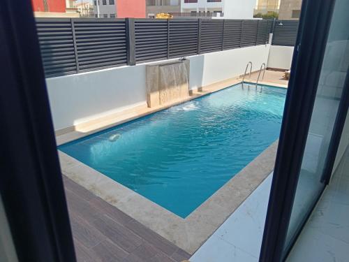 a swimming pool seen through the window of a building at Villa Chez Badre with Pool High Standing in Sidi Rahal