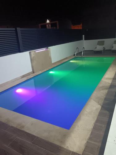 a swimming pool at night with blue and green at Villa Chez Badre with Pool High Standing in Sidi Rahal