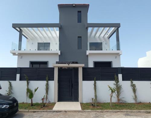 a large white building with a gate in front of it at Villa Chez Badre with Pool High Standing in Sidi Rahal