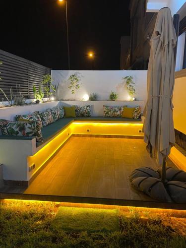 a patio with an umbrella and a bench with a table at Villa Chez Badre with Pool High Standing in Sidi Rahal