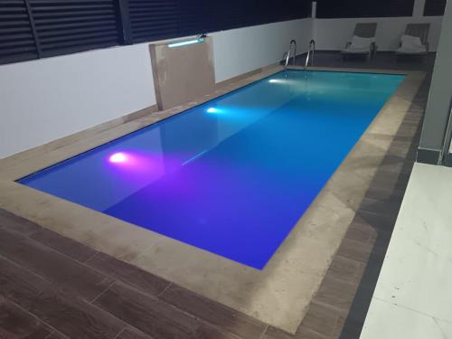 a swimming pool with a blue floor in a building at Villa Chez Badre with Pool High Standing in Sidi Rahal