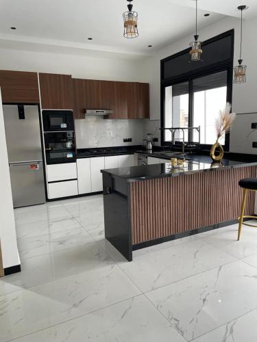 a kitchen with a black and white counter top at Villa Chez Badre with Pool High Standing in Sidi Rahal
