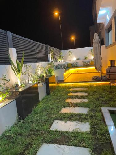a backyard at night with a grassy yard and a patio at Villa Chez Badre with Pool High Standing in Sidi Rahal