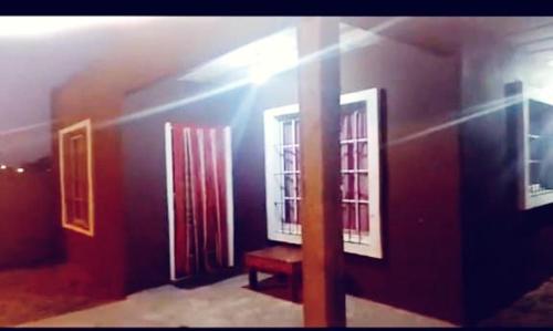 a room with two windows and a red bench at junior alquileres in San Clemente del Tuyú