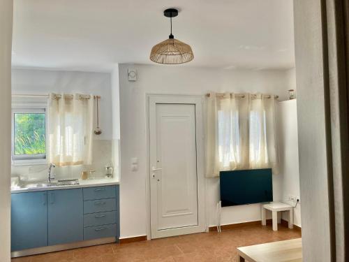 a bathroom with a sink and a white door at The Little House by the Sea in Paralía