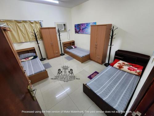 a room with three bunk beds in a room at Galaxia Imparcial Male Accommodation in Doha