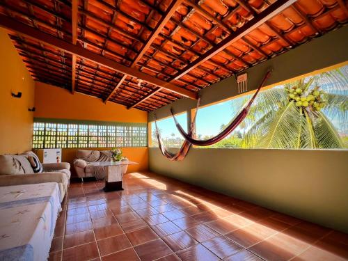 a living room with a couch and a large window at Casa Mandacaru Pousada in Caucaia