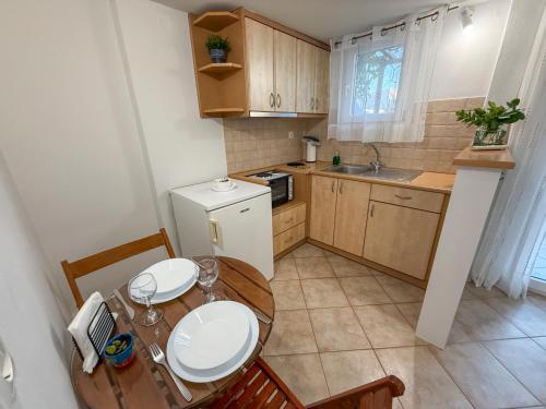 a small kitchen with a table and chairs and a sink at Anastasaki Studios in Tinos Town