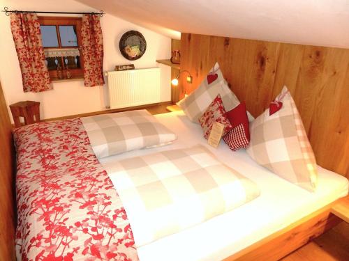 a bedroom with a large bed with wooden walls at Gästehaus Schönfeld in Reit im Winkl