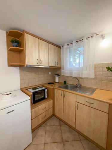 a small kitchen with wooden cabinets and a sink at Anastasaki Studios in Tinos Town