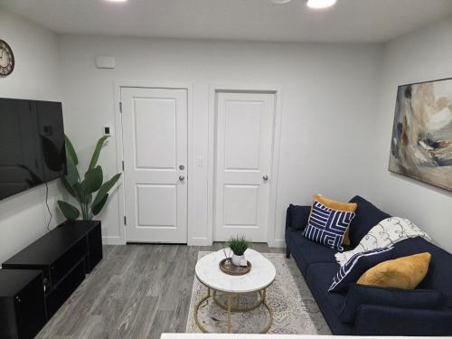 a living room with a blue couch and a table at Modern 2BR near Hospital, YMCA, Stores in Calgary