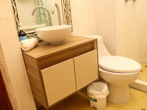 a bathroom with a toilet and a bowl on a counter at Casa Zarah - Alma Hotels in Santa Marta