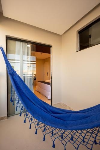 a blue hammock in a room with a bedroom at Aira Hotel in Sobral