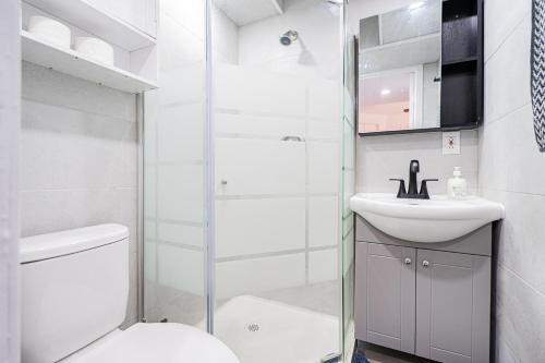 a bathroom with a shower and a toilet and a sink at Studio pratique pour deux personnes au centre ville in Montréal