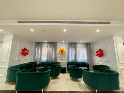 a waiting room with green chairs and red balloons at Cent Al Azizia Hotel Makkah in Makkah