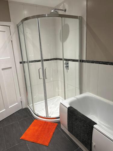a shower in a bathroom with an orange rug at Charming Home Nottingham City in Lace Market Free parking in Nottingham
