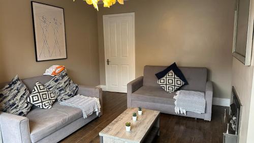 a living room with two couches and a coffee table at Charming Home Nottingham City in Lace Market Free parking in Nottingham