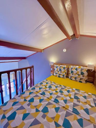 a bedroom with a colorful bed in a room at Studio La Case Bourbon in Sainte-Anne