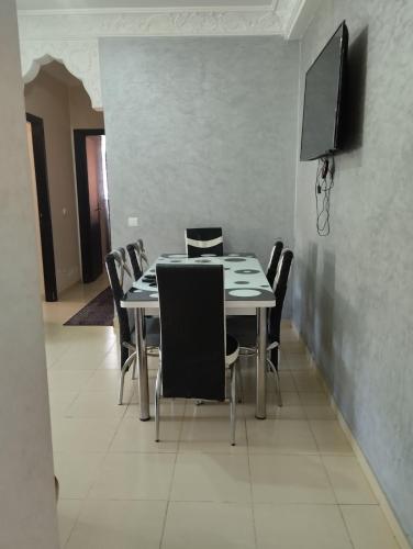 a dining room with a table with chairs and a flat screen tv at jardaine d'Ifrane in Ifrane