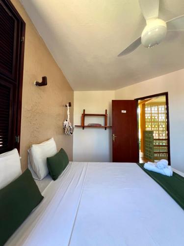 a bedroom with a large white bed with a ceiling at Casa Mandacaru Pousada in Caucaia