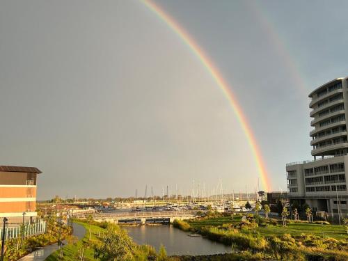 a rainbow over a river in a city at Mia Mia at the Marina in Shellharbour