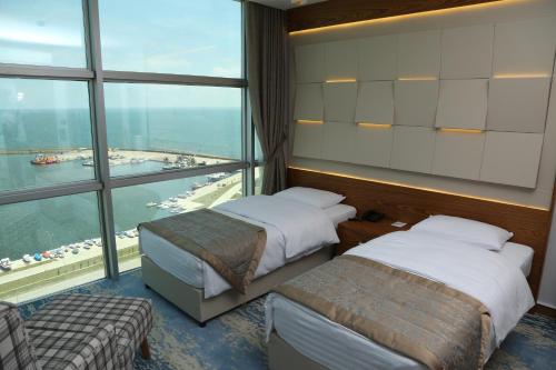 a hotel room with two beds and a large window at Panaroma Damla Otel in Samsun