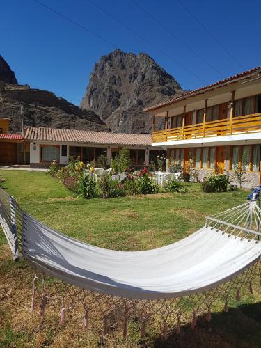 a hammock in a yard in front of a building at Hotel Tierra Inka Sacred Valley in Ollantaytambo
