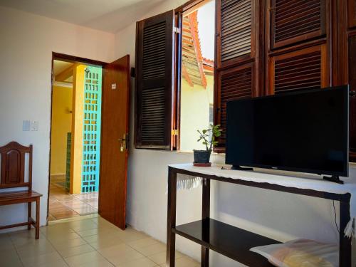 a living room with a flat screen tv on a table at Casa Mandacaru Pousada in Caucaia