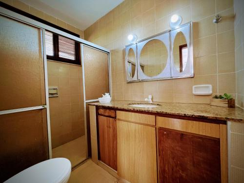 a bathroom with a toilet and a sink and a mirror at Casa Mandacaru Pousada in Caucaia