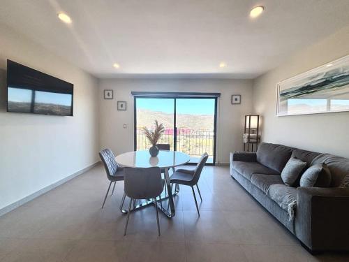 a living room with a couch and a table and chairs at Vinedos del Mar 2BR 2BA with pool in Ensenada