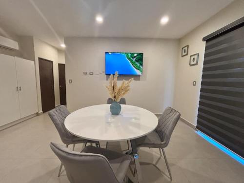 a white dining room with a white table and chairs at Vinedos del Mar 2BR 2BA with pool in Ensenada