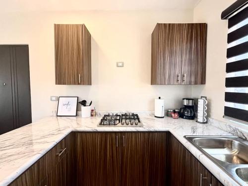 a kitchen with a sink and a stove top oven at Vinedos del Mar 2BR 2BA with pool in Ensenada