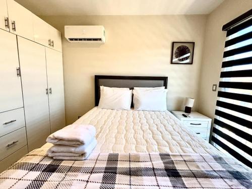 a bedroom with a bed with a checkered blanket at Vinedos del Mar 2BR 2BA with pool in Ensenada