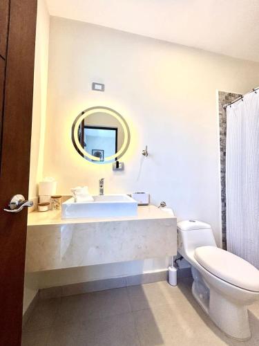 a bathroom with a sink and a toilet and a mirror at Vinedos del Mar 2BR 2BA with pool in Ensenada