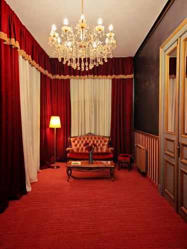 a living room with a couch and a chandelier at Noblesse Palace Old Town by NF in Bucharest